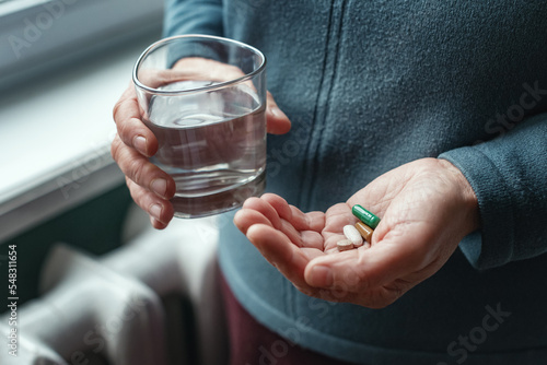 Foto Woman holding a pill and a glass of water, ready to take her medicine