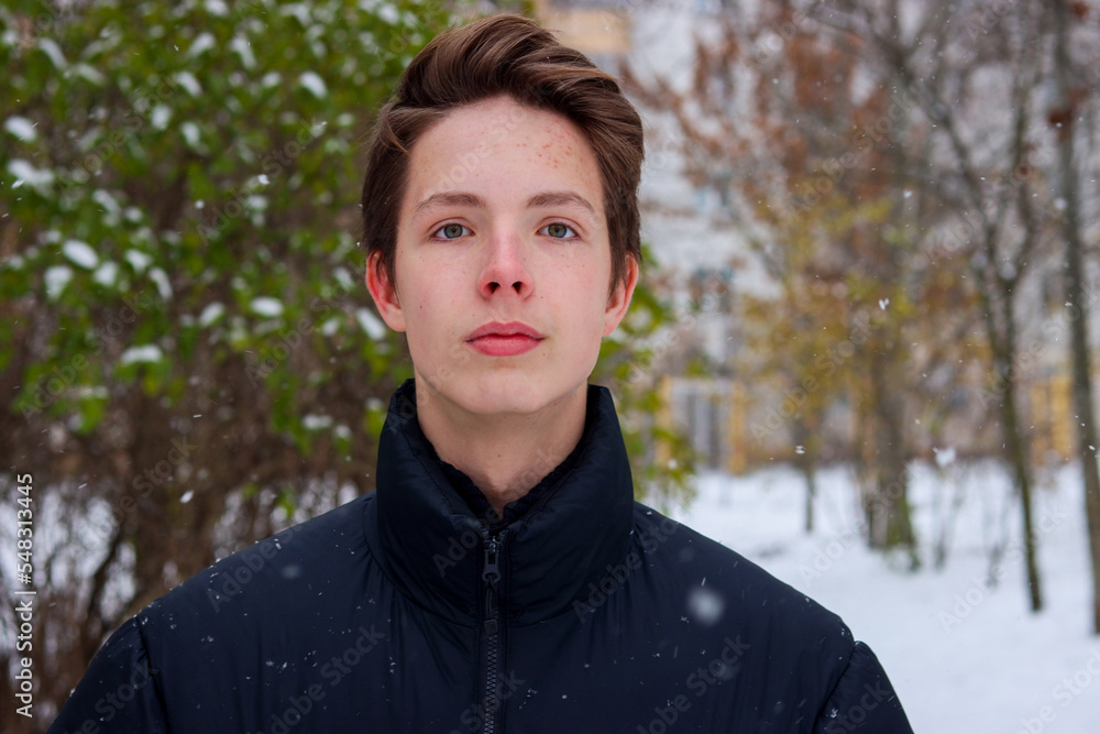 Winter portrait of a 17-year-old boy in the courtyard of the house. Winter portrait of a 17-year-old boy in the courtyard of the house.