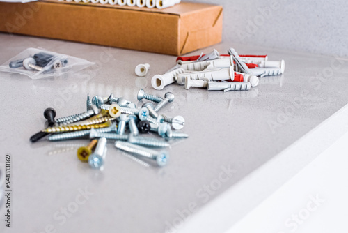 Un conjunto de tornillos y tacos  sobre una mesa de mármol gris. Concepto de herramientas para una reforma. Bricolaje. photo
