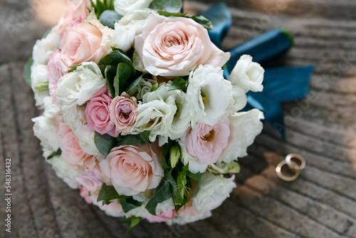 Wedding rings and bouquet on background