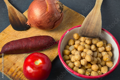 Ingredients for a chickpea stew with chorizo, onion and tomato