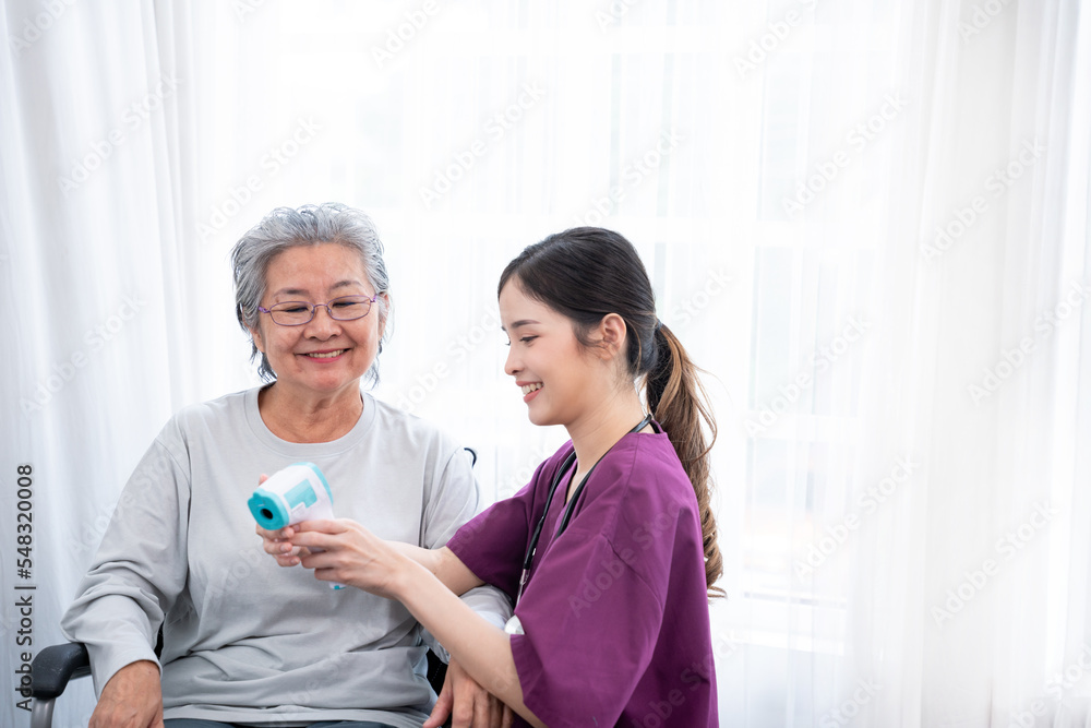Nurse is caregiver and measuring body temperature senior woman in Home. Home care concept.. Nurse is caregiver and measuring body temperature senior woman in Home. Home care concept..