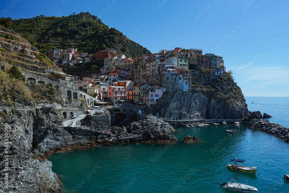 The small town of Manarola, Italy, One of the Cinque Terre villages and one of the most famous views in Italy, during an autumn day - October 2022.
