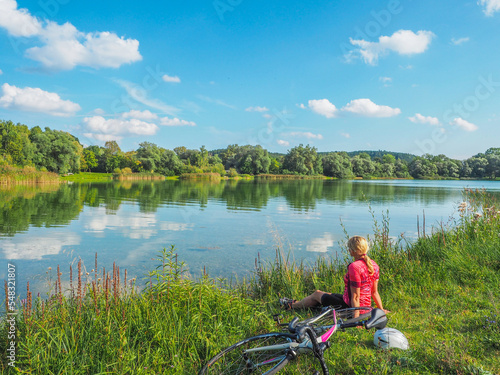 Rennrad fahren nördlich von München - Radfahrerin macht Pause am See