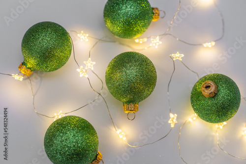 Christmas composition of green balls and lights on the white background
