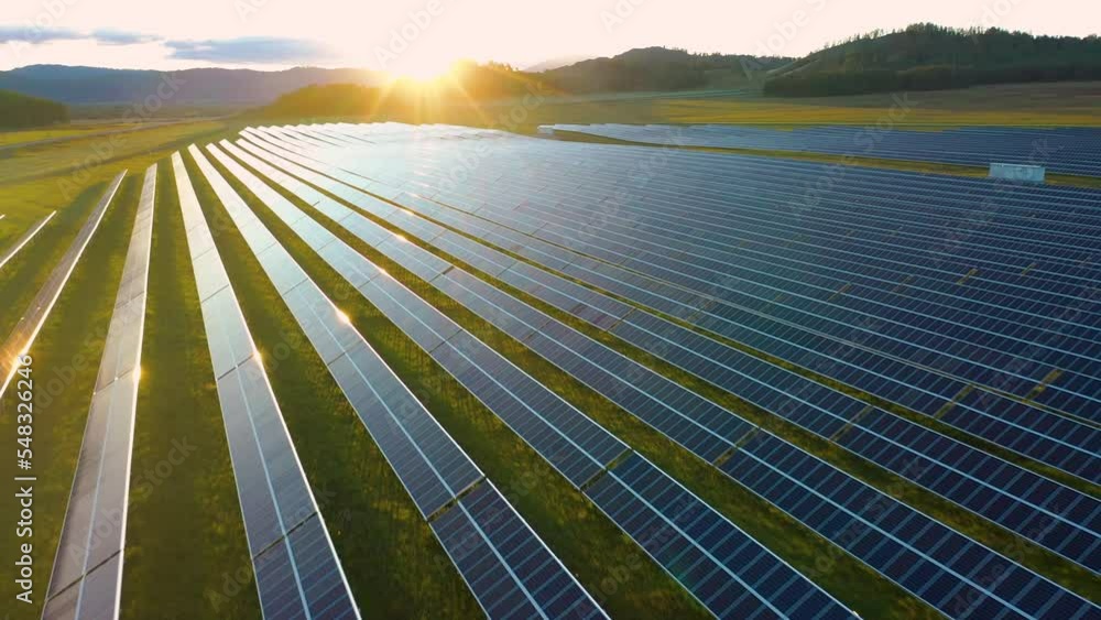 Ecology solar power station panels in the field, green energy at amazing sunset. Electrical innovation nature environment, landscape. Aerial drone shot