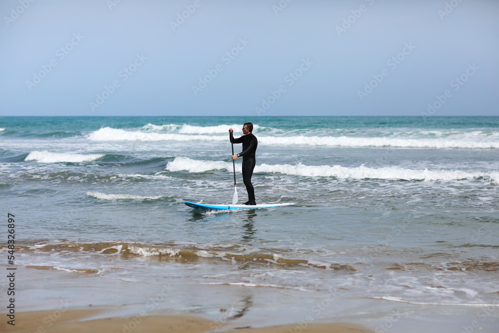 Stand up paddle boarding. Young man floating on a SUP board. The adventure of the sea with blue water on a surfing. High quality photo Stand up paddle boarding. Young man floating on a SUP board. The adventure of the sea with blue water on a surfing. High quality photo