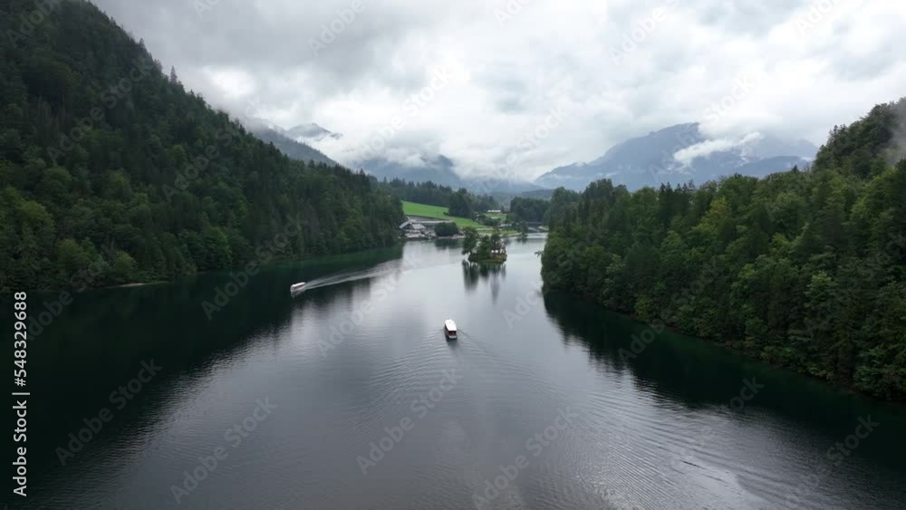 Misty clouded mountain lake. Dark grey mysterious rainy majestic spooky inland water. Small tour boat on the water. Peacufull forest lake in europe. Aerial drone overhead view. Misty clouded mountain lake. Dark grey mysterious rainy majestic spooky inland water. Small tour boat on the water. Peacufull forest lake in europe. Aerial drone overhead view.