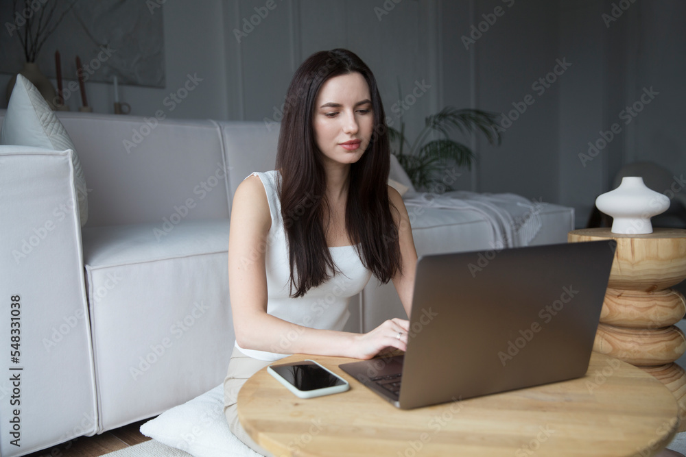 work from vacation home, remote workers. Working from Anywhere. woman freelancer connecting to the Internet from home. The adorable young woman using a laptop, in a stylish living room. work from vacation home, remote workers. Working from Anywhere. woman freelancer connecting to the Internet from home. The adorable young woman using a laptop, in a stylish living room.
