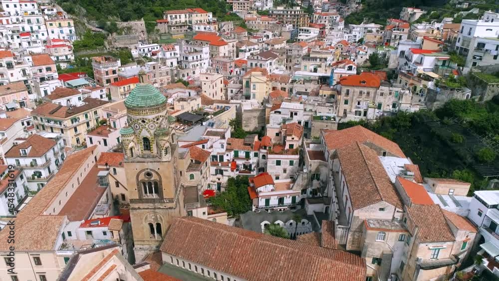 Aerial view of Amalfi Coast, Italy. Drone view of Cathedral of Saint Andrew, embankment, red roofs of buildings in old town, historical and tourist places, and cruise ship Aerial view of Amalfi Coast, Italy. Drone view of Cathedral of Saint Andrew, embankment, red roofs of buildings in old town, historical and tourist places, and cruise ship