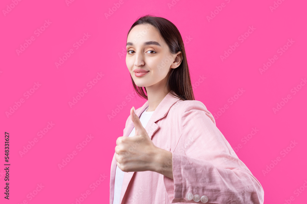 Happy young caucasian female in an pink jacket making thumb up sign and smiling. Good job and respect. Happy young caucasian female in an pink jacket making thumb up sign and smiling. Good job and respect.