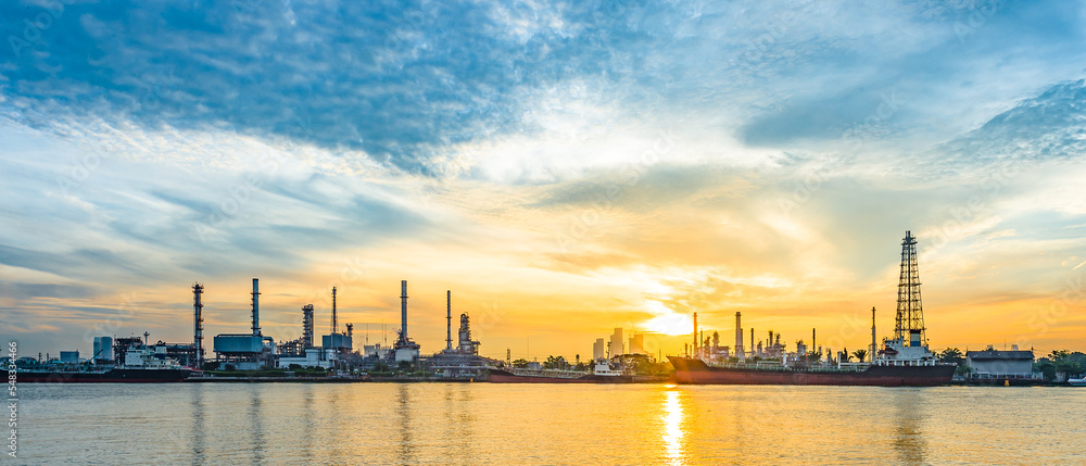 Oil refinery or petrochemical plant with reflection at sunrise