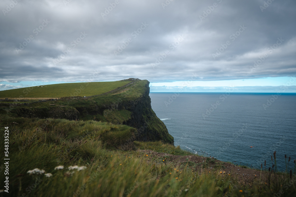 Spectacular view of famous Cliffs of Moher and wild Atlantic Ocean, cloudy day, County Clare, Ireland.