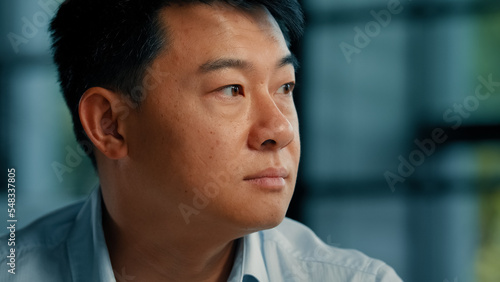 Businessman employer ethnic asian korean man sit alone in office thoughtful looking at window planning business idea turning head to camera smiling sincere toothy smile confident male portrait indoors