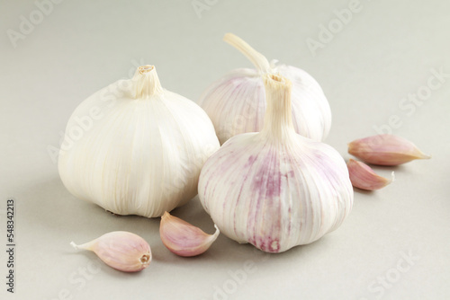 Fresh white unpeeled head bulb of garlic and garlic cloves on white color background. Vegan, organic, vitamins. Natural antibiotic, antioxidant, Allicin. 