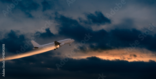 A tourist plane takes off in a cloudy evening sky with an abstract line of light behind it. commercial aircraft