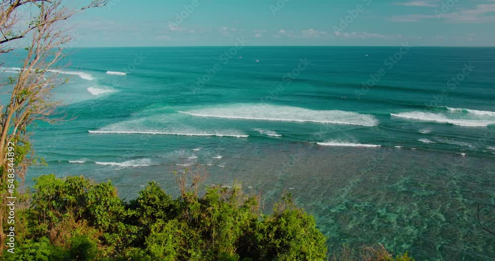 Wide ocean waves rush to the shore in summer sunny day Green Bowl Beach Bali Island. Small serene surfing spot. Turquoise blue crystal clear water foam. Peaceful zen nature background. Wide ocean waves rush to the shore in summer sunny day Green Bowl Beach Bali Island. Small serene surfing spot. Turquoise blue crystal clear water foam. Peaceful zen nature background.