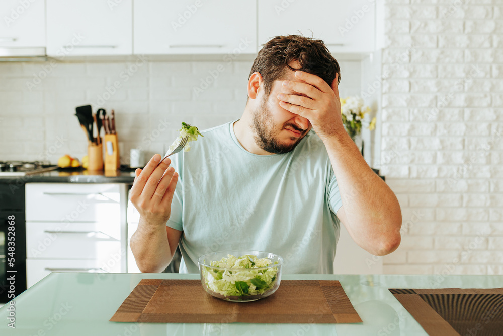 A young guy is tired from eating light food, closing his eyes, he ...