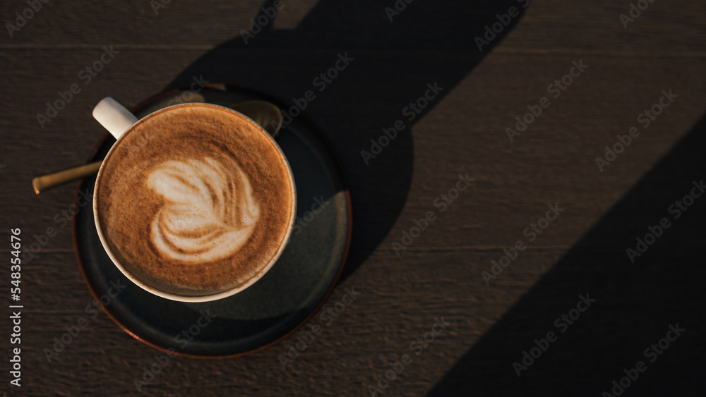 A cup of coffee on a wooden table closeup. A cup of coffee on a wooden table closeup.