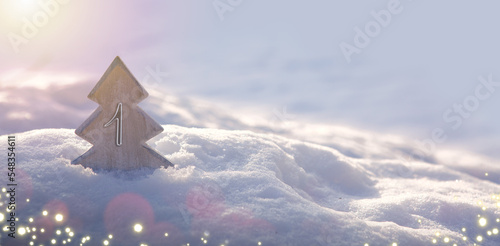 First Advent. Christmas background with fir tree and lights on snow.