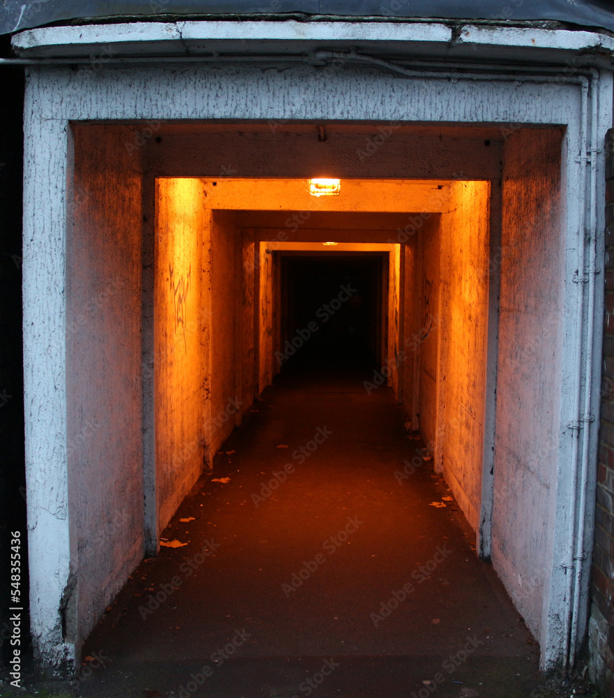 Deep tunnel, with viewpoint on other side  with yellow light. Dark tunnel in urban. Scary tunnel 
