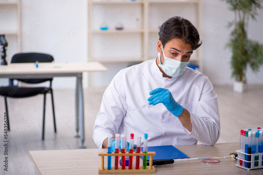 Young male chemist working at the lab Young male chemist working at the lab