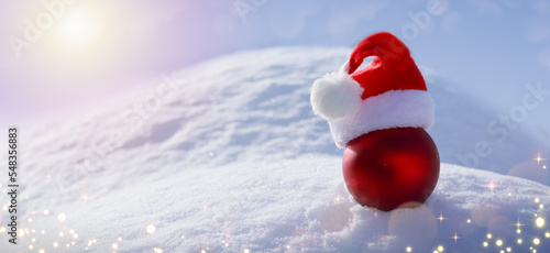 Christmas background with red ball on white snow.