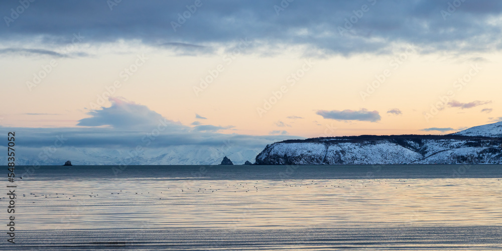 Beautiful panoramic seascape. View of the sea, cape and rocks. Cold weather. Nature of Siberia and the Russian Far East. Travel and tourism in the Magadan region. Gertner Bay, Sea of Okhotsk, Russia.