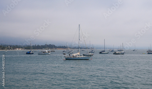 Sailboats standing in front of the coast of Santa Barbara, California, near Stearns Wharf.