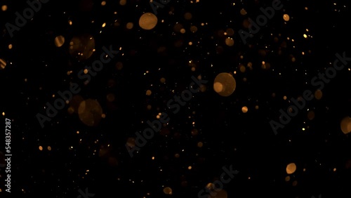 Glitter background in 4k resolution. with alpha channel. Real particles flying in wind on black background, shot with depth of field. 