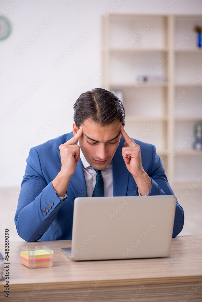 Young male employee working in the office Young male employee working in the office