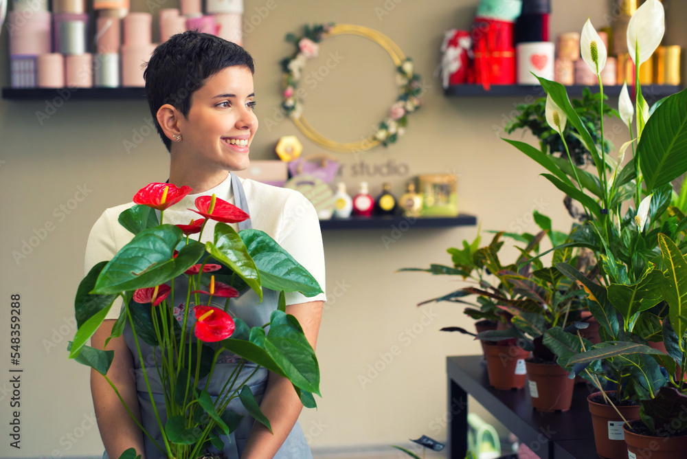 Fototapeta premium Young woman professional florist working with flowers in her flower shop 
