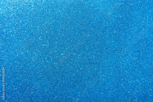 Background with sparkles. Backdrop with glitter. Shiny textured surface. Strong blue