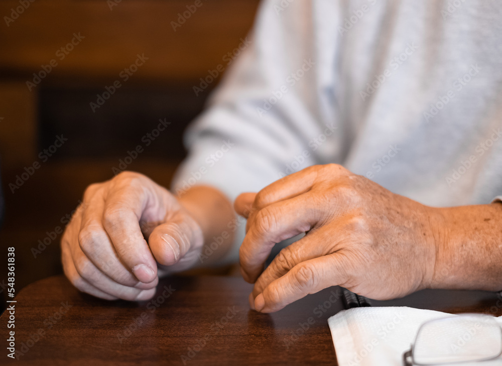 Obraz premium Man hands resting on a wooden table. Close up of Hands of a man. Male hands