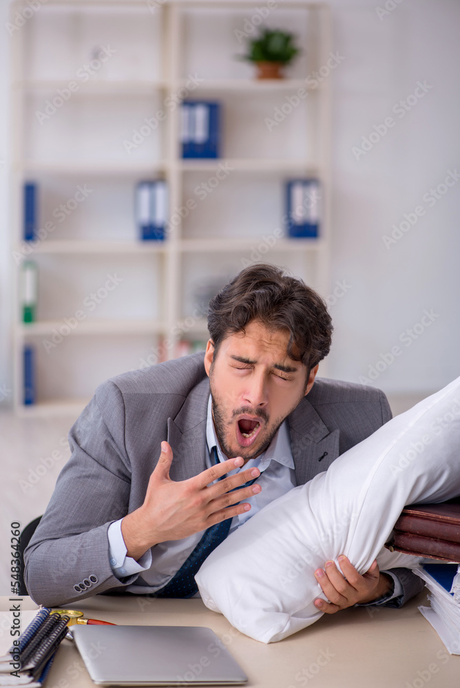 Young male employee in oversleeping concept Young male employee in oversleeping concept