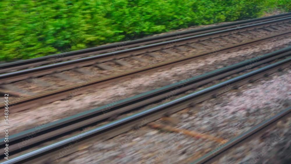 Transport, travel, road, railway, landscape, comnication concept - view from window of speed train on landscape of beautiful nature field road. View on railroad track from the window of fast train Transport, travel, road, railway, landscape, comnication concept - view from window of speed train on landscape of beautiful nature field road. View on railroad track from the window of fast train