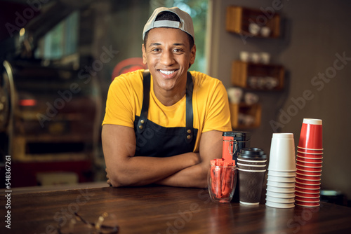 Joyful barista posing for the camera in a coffee shop