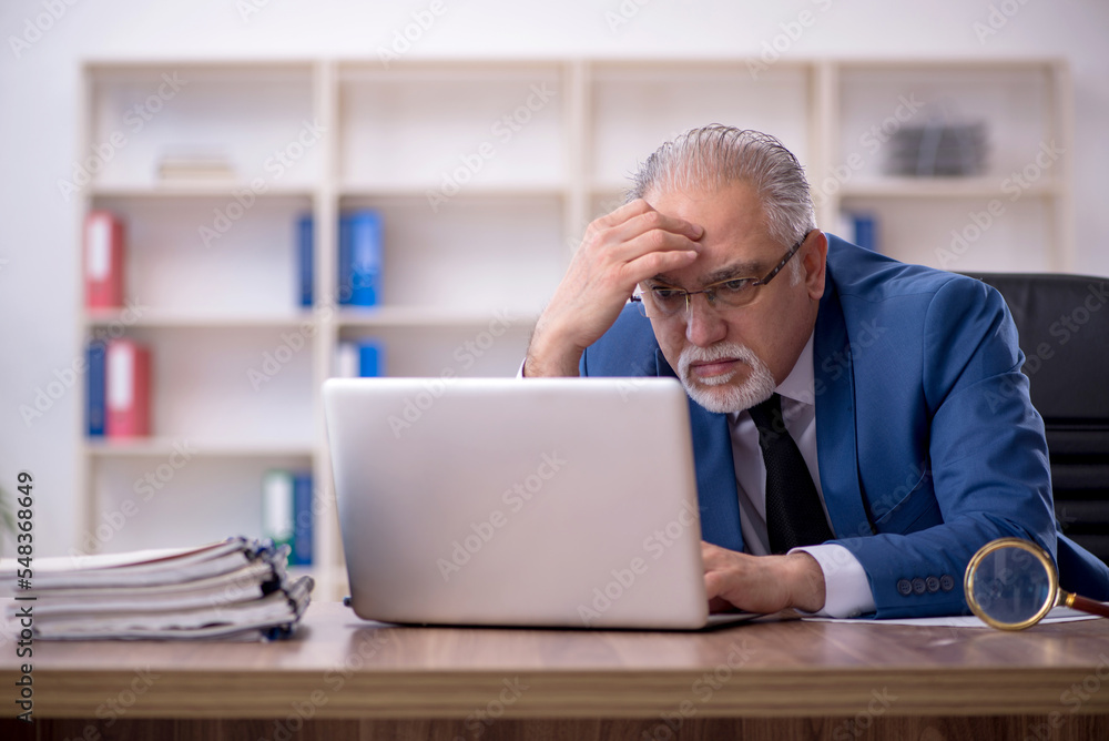 Old male employee working in the office Old male employee working in the office