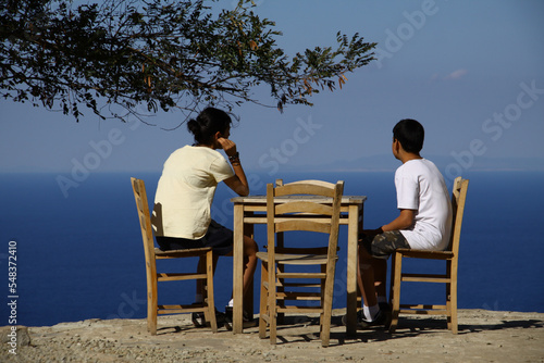 Siblings sitting at a café and watching the Aegean Sea in Gokceada.  © ogdum