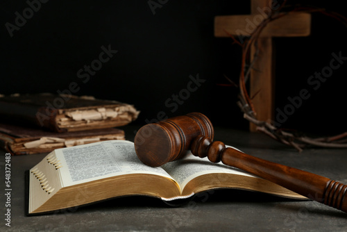 Judge gavel, bible, wooden cross and crown of thorns on grey table photo