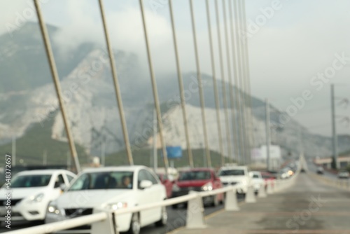 Blurred view of modern bridge and cars near mountain © New Africa