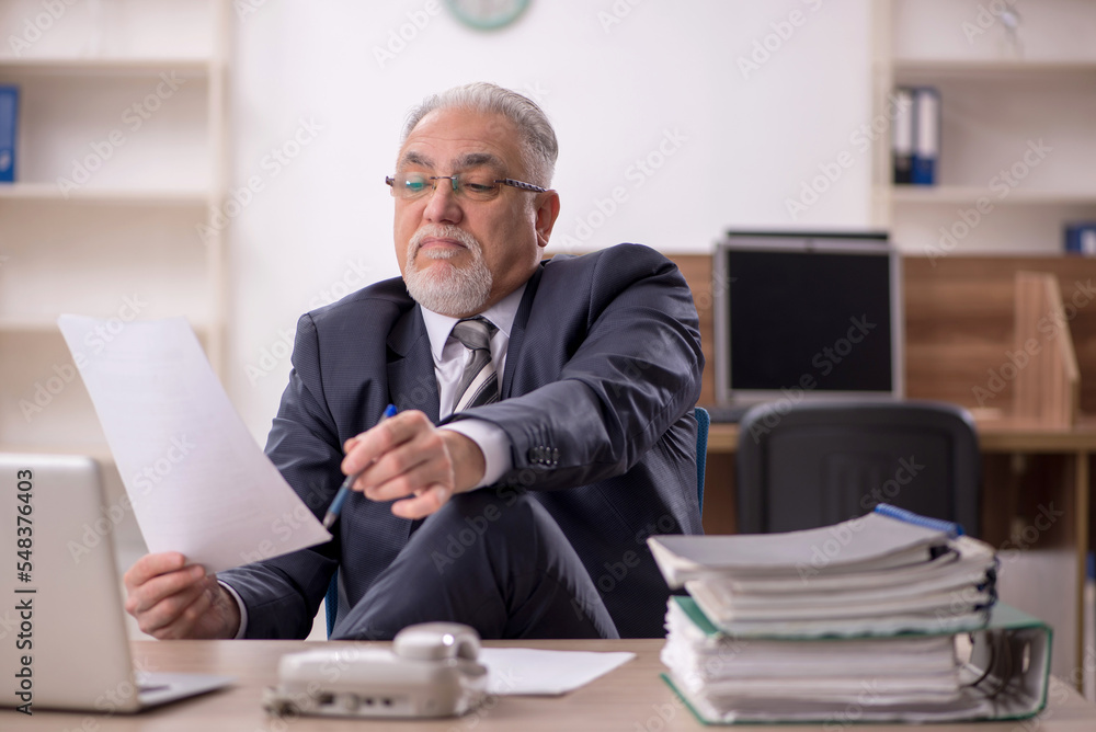 Old male boss employee working in the office Old male boss employee working in the office