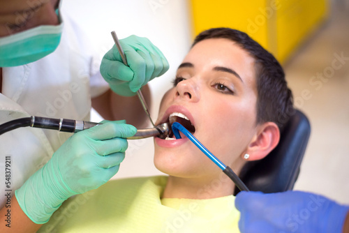 Young woman checking her teeth at the dentist clinic 