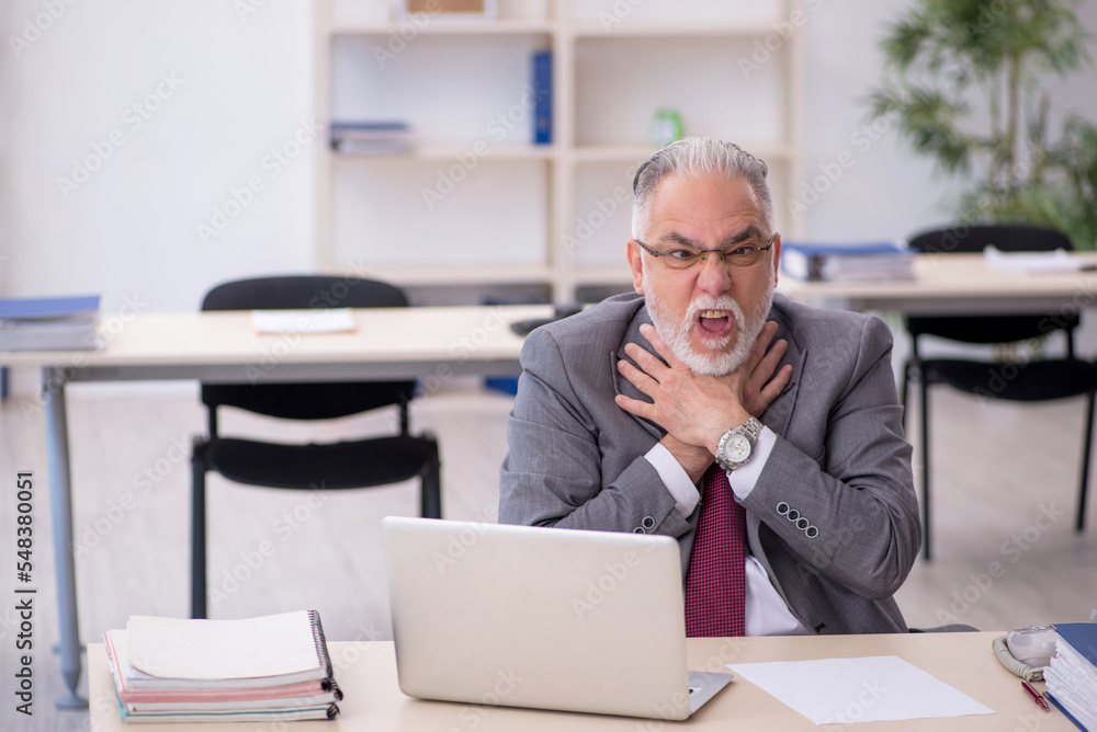 Old male employee working in the office Old male employee working in the office