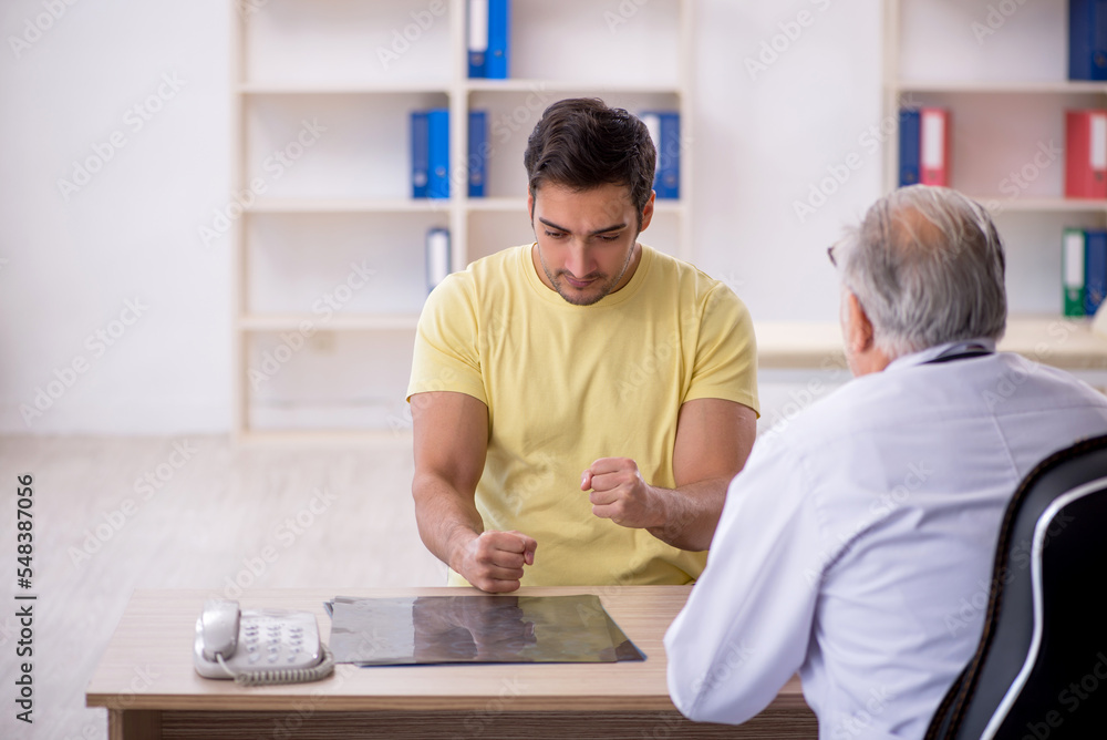 Obraz premium Young male patient visiting old male doctor