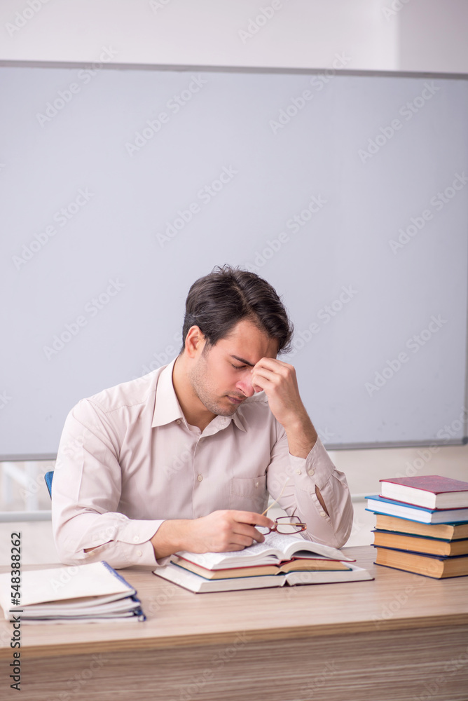 Young male teacher student sitting in the classroom Young male teacher student sitting in the classroom