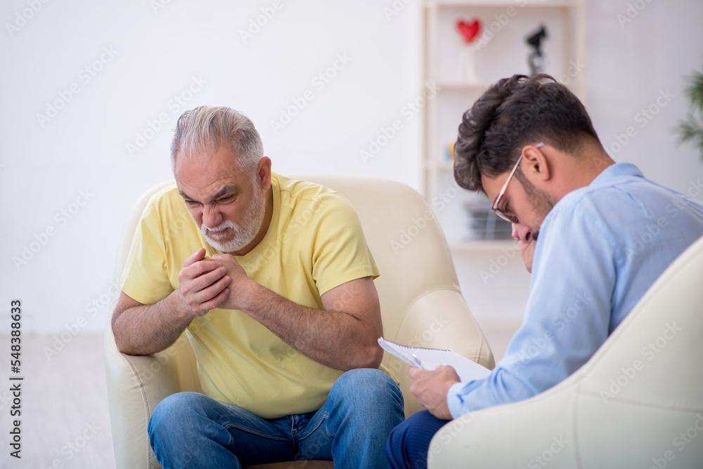 Fototapeta premium Old man visiting young male psychotherapist