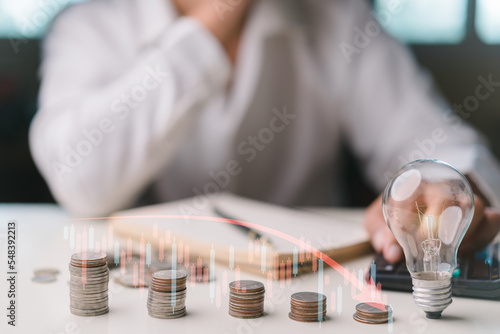 Businessman taking notes and using calculator to calculate, Stacking coins, graph icon, light bulb. Plan revenue and expenses, target success growth, finance profit planning 2023.