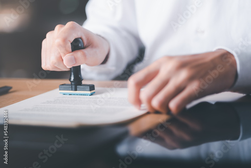Businessman validates and manages business documents and agreements, signing a business contract approval of contract documents confirmation or warranty certificate,approval stamp