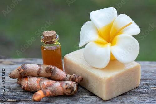 Turmeric  essential oil bar soap and flower candle on wooden background. spa concept.